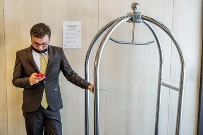 Um funcionário de um hotel em Bogotá usa seu celular.