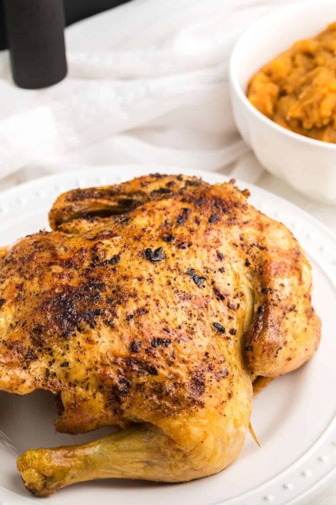 Air Fryer Frango inteiro em um prato branco