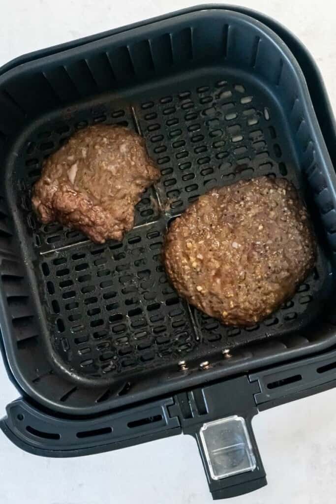 Visão aérea de dois bifes de cubo em uma cesta de fritadeira.