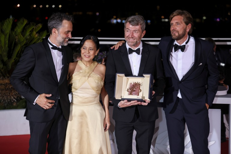 Erik Hemmendorff, da esquerda, Dolly De Leon, Philippe Bobe, diretor Ruben Ostlund posam com o prêmio Palm d'Or de "Triângulo da Tristeza" durante a sessão de fotos após a cerimônia de premiação no 75º festival internacional de cinema, Cannes, sul da França, sábado, 28 de maio de 2022.