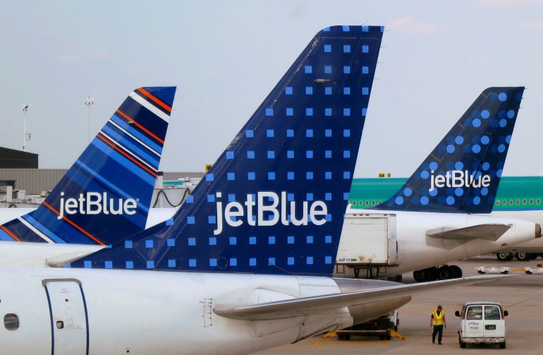 A cauda de vários aviões da JetBlue, onde o logotipo da empresa pode ser visto em fundos padronizados.