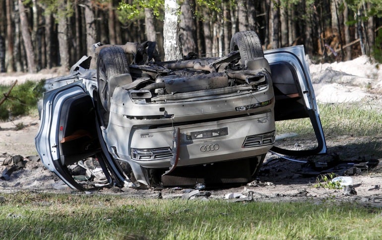 O carro de Zakhar Prilepin está capotado em uma pista próxima à floresta após a explosão de uma bomba.