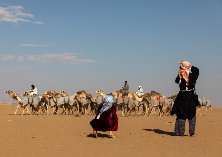 Turistas tirando fotos durante o treinamento para corridas de camelos