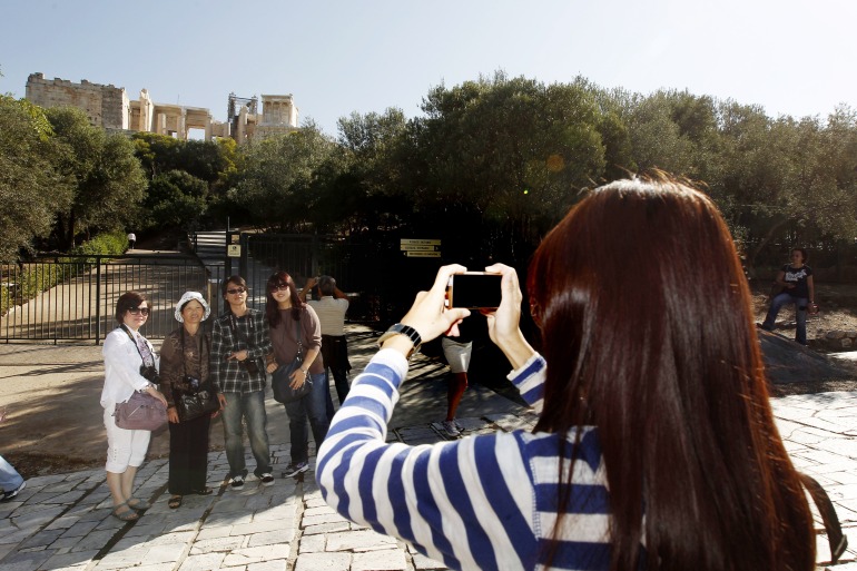 Turistas chineses tirando fotos com a Acrópole ao fundo