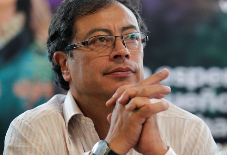 O candidato presidencial colombiano Gustavo Petro se reúne com apoiadores antes da corrida presidencial de domingo.  Ele é visto em uma camisa de colarinho branco, com as mãos cruzadas perto do rosto.