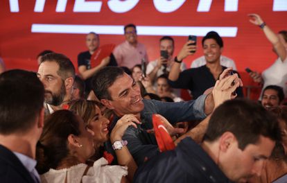 O candidato socialista, Pedro Sánchez, é fotografado com um celular enquanto outros militantes tiram fotos do comício para compartilhar nas redes.