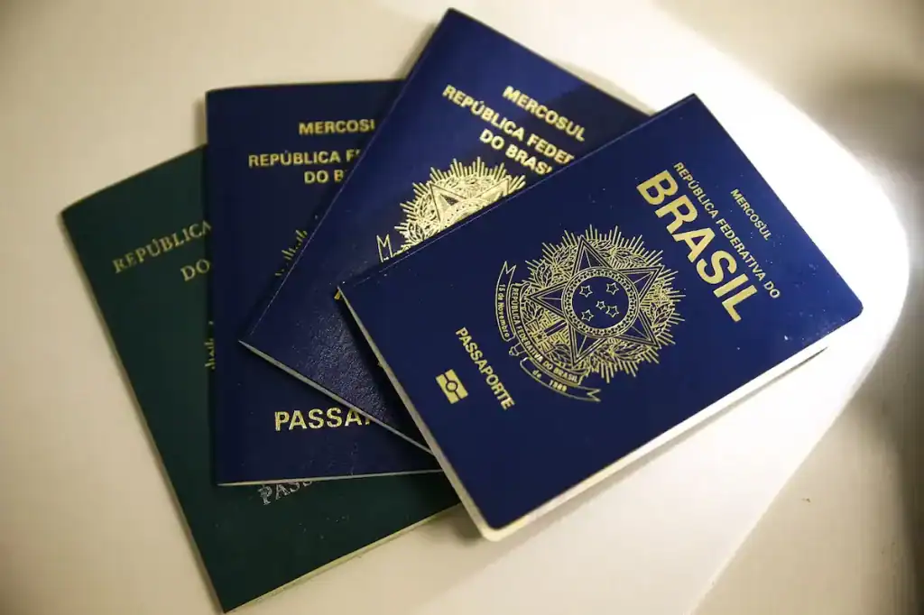 Capa azul do passaporte brasileiro em destaque na mesa da Polícia Federal.