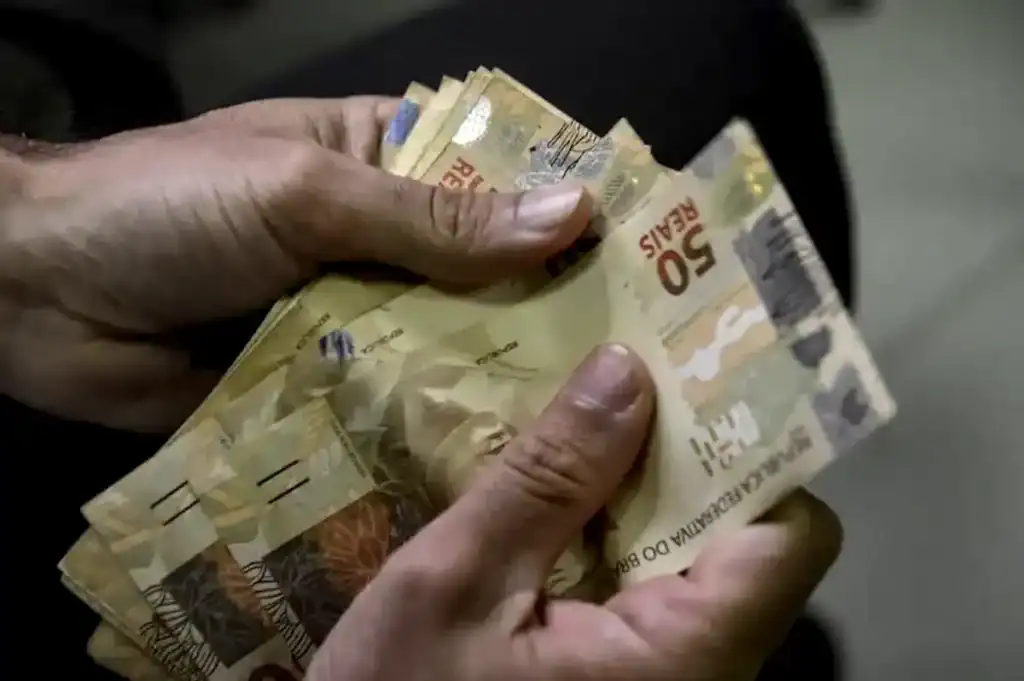 Pilhas de notas de real (dinheiro) sobre uma mesa