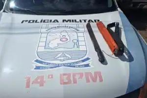 Foto de facão apreendido sobre capô de viatura policial