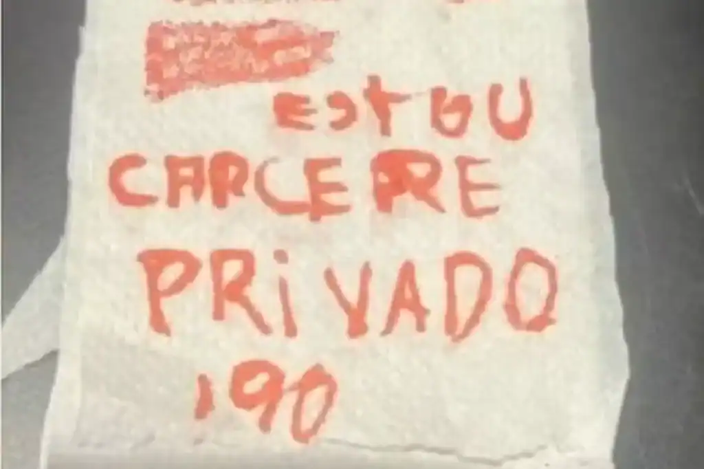 Pedaço de papel higiênico com um bilhete manuscrito pedindo socorro.
