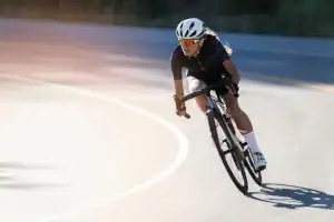 Ciclista ajustando uma meia de compressão de cano alto em fibra tecnológica