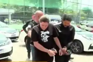 Captura de tela de Belão sendo escoltado após prisão em megaoperação policial