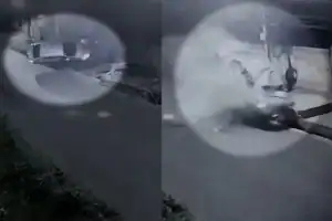 Foto em preto e branco de carro capotado após atingir poste na rua