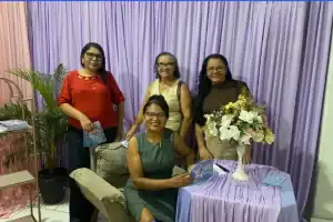 A escritora Francisca Ferreira autografando exemplares de Devaneios Poéticos durante o lançamento no Centro de Formação Paroquial de Amarante.