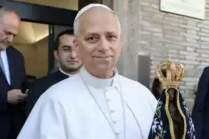 Papa em vestes brancas sentado, aprovando instrução doutrinária do vaticano