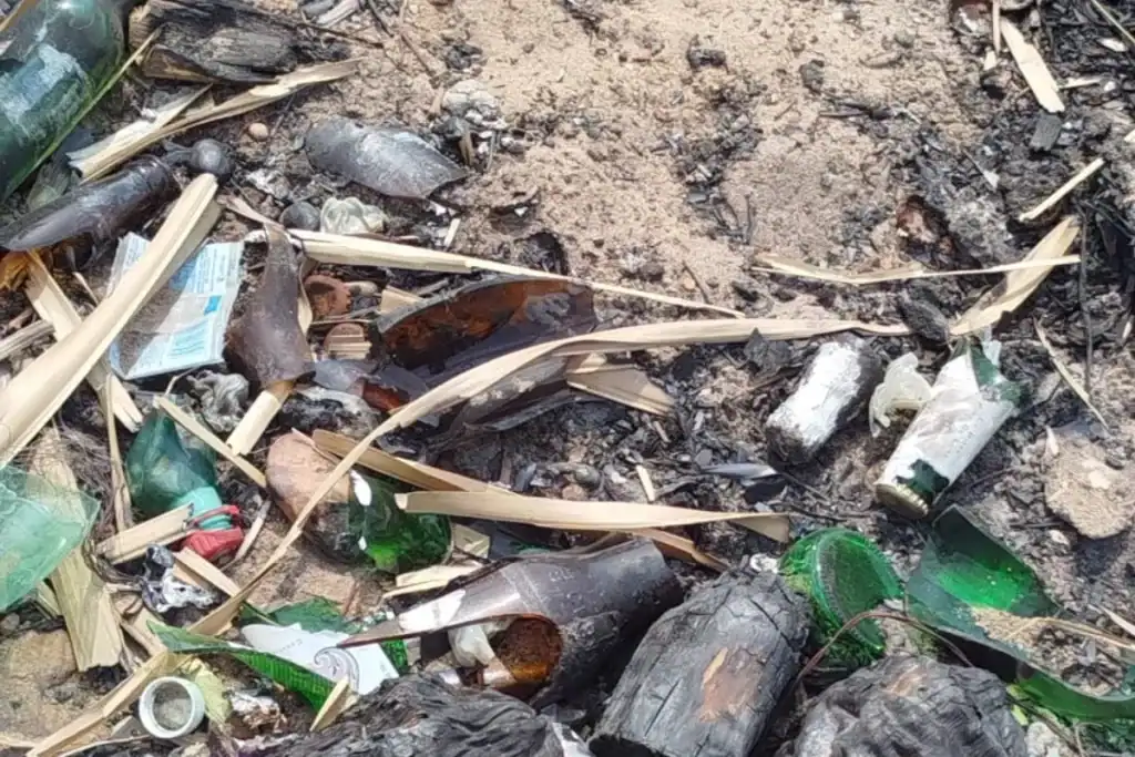 Acúmulo de cacos de vidro na areia da Prainha Veredinha