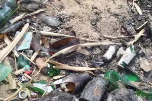 Acúmulo de cacos de vidro na areia da Prainha Veredinha