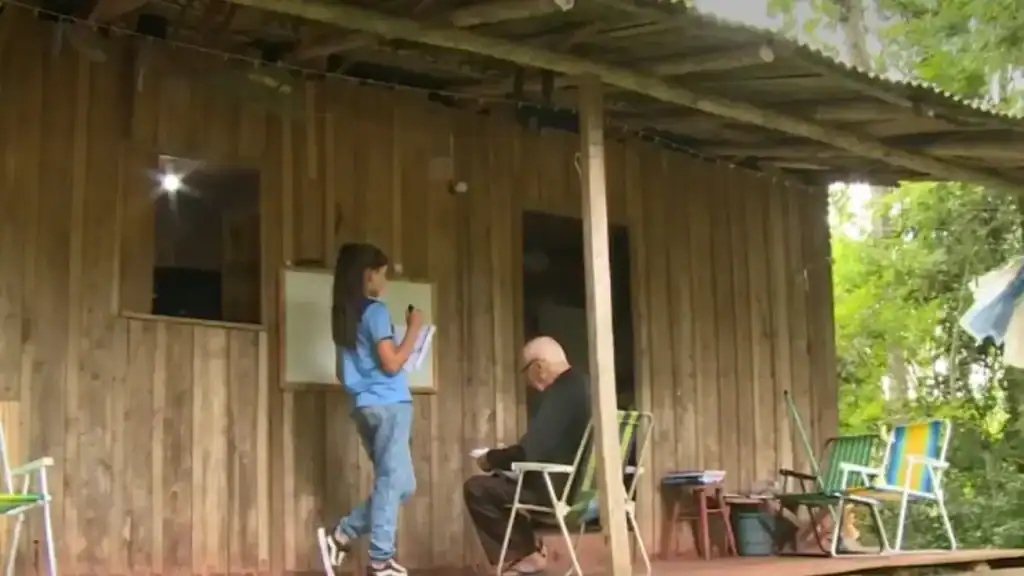 Brenda Schiavo, 11 anos, ensinando seu bisavô Pedro Donato, 91 anos, a ler e escrever em Águas Frias, Santa Catarina.