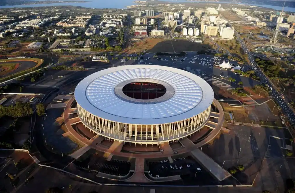 Logos do Flamengo e Corinthians lado a lado, com o troféu da Supercopa Rei 2026 ao centro e o Estádio Mané Garrincha ao fundo, simbolizando o confronto em Brasília.