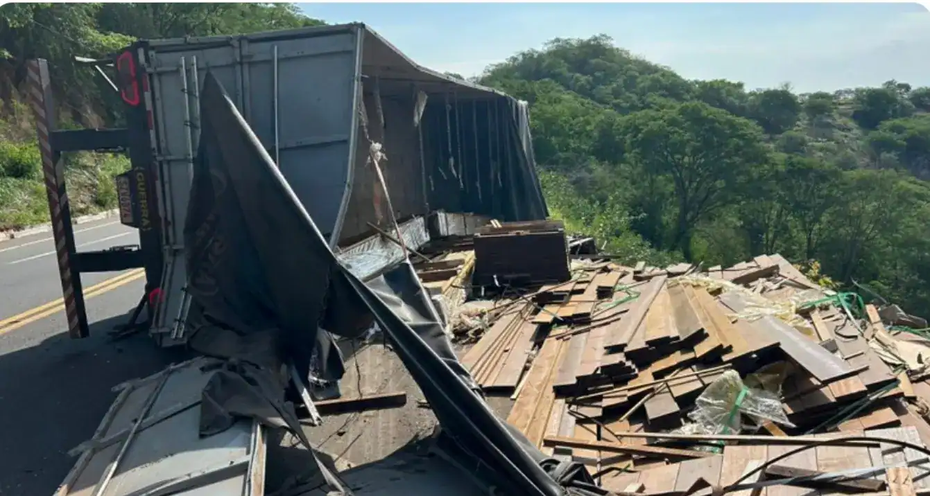 Carreta branca tombada na BR-316 em Picos, com carga de madeira espalhada e agentes da PRF gerenciando o local.