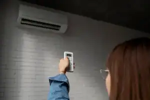 Aparelho de ar-condicionado Split Inverter instalado em uma parede branca, com o display digital exibindo a temperatura ambiente