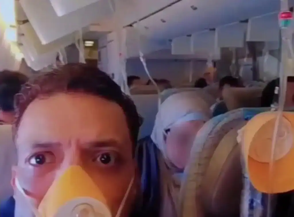 Passageiros com máscaras de oxigênio ativadas dentro da cabine de um avião da Emirates durante emergência de despressurização.