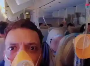 Passageiros com máscaras de oxigênio ativadas dentro da cabine de um avião da Emirates durante emergência de despressurização.