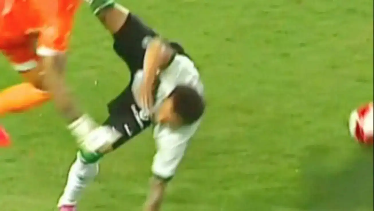 Lucas Crepaldi, atacante do Coritiba, caído no gramado segurando o antebraço esquerdo fraturado durante jogo do Campeonato Paranaense.