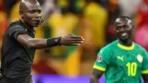 Jogadores da seleção de Senegal celebram a vitória e o título da Copa Africana de Nações, erguendo o troféu em campo.