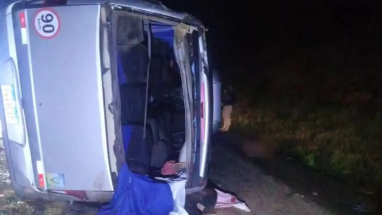 Micro-ônibus branco e caminhão de carga danificados após colisão na BR-116, com equipes de resgate e veículos de emergência no local do acidente.