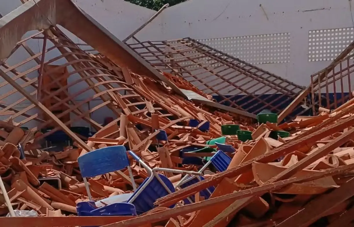 Auditório da Escola Municipal Tomé de Sousa em Imperatriz, Maranhão, com teto desabado e telhas caídas sobre as cadeiras após fortes chuvas.