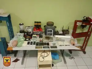 Policiais exibem grande quantidade de cocaína, maconha, crack, prensas hidráulicas e equipamentos de laboratório de drogas apreendidos em São Julião, Piauí.