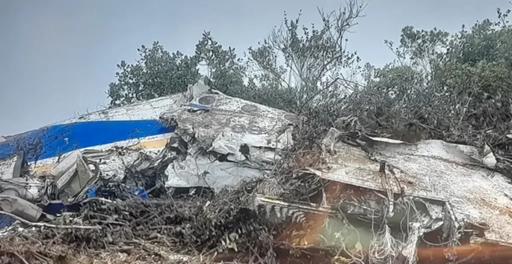 Destroços do avião Satena Beechcraft 1900 HK4709 após queda em área rural de La Playa de Belén, Colômbia, com fumaça visível.