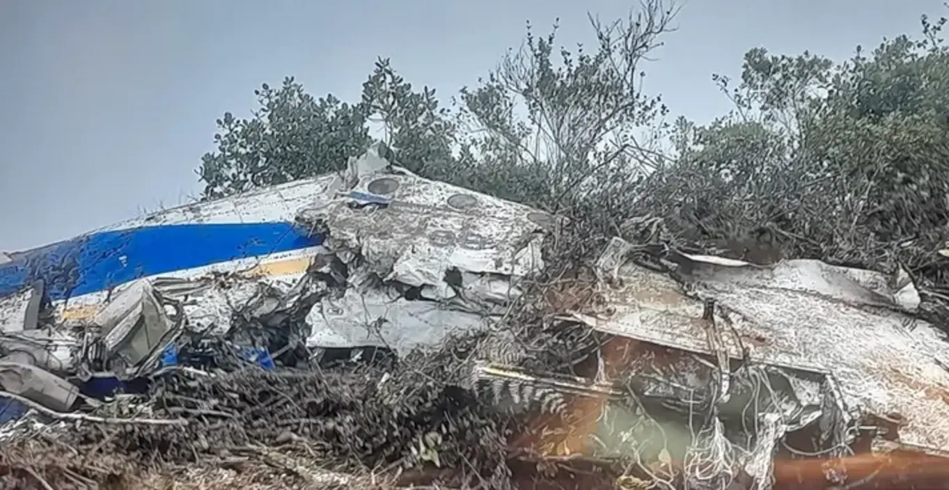 Destroços do avião Satena Beechcraft 1900 HK4709 após queda em área rural de La Playa de Belén, Colômbia, com fumaça visível.