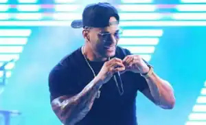 Foliões dançam e celebram em rua de Amarante durante o Zé Pereira, com trio elétrico ao fundo.