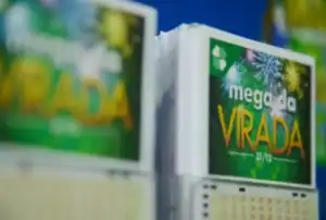 Mãos segurando bilhete da Mega da Virada e notas de dinheiro, simbolizando o resgate do prêmio.