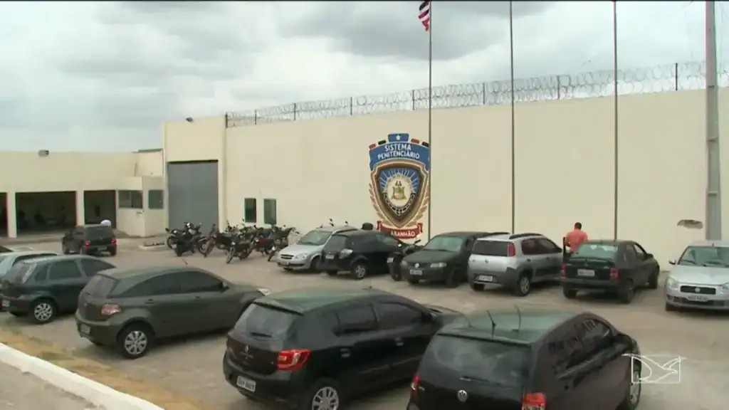 Portão de presídio com grades e muro alto, simbolizando o sistema prisional e a saída temporária de detentos no Maranhão.
