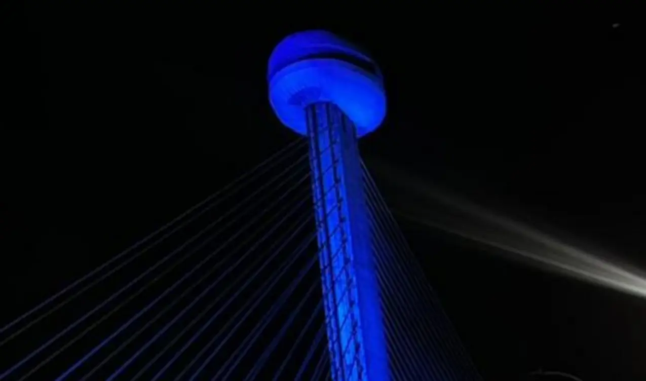 Ponte Estaiada de Teresina à noite, com sua estrutura principal e cabos iluminados em um tom vibrante de azul, em homenagem a policiais mortos em serviço.