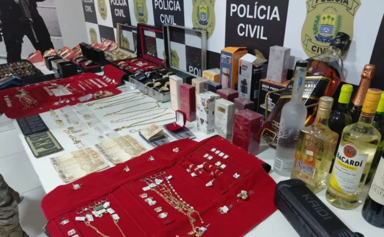 Joias como anéis, colares e pulseiras, além de outros objetos de valor, expostos sobre uma mesa após serem recuperados pela Polícia Civil em Teresina.