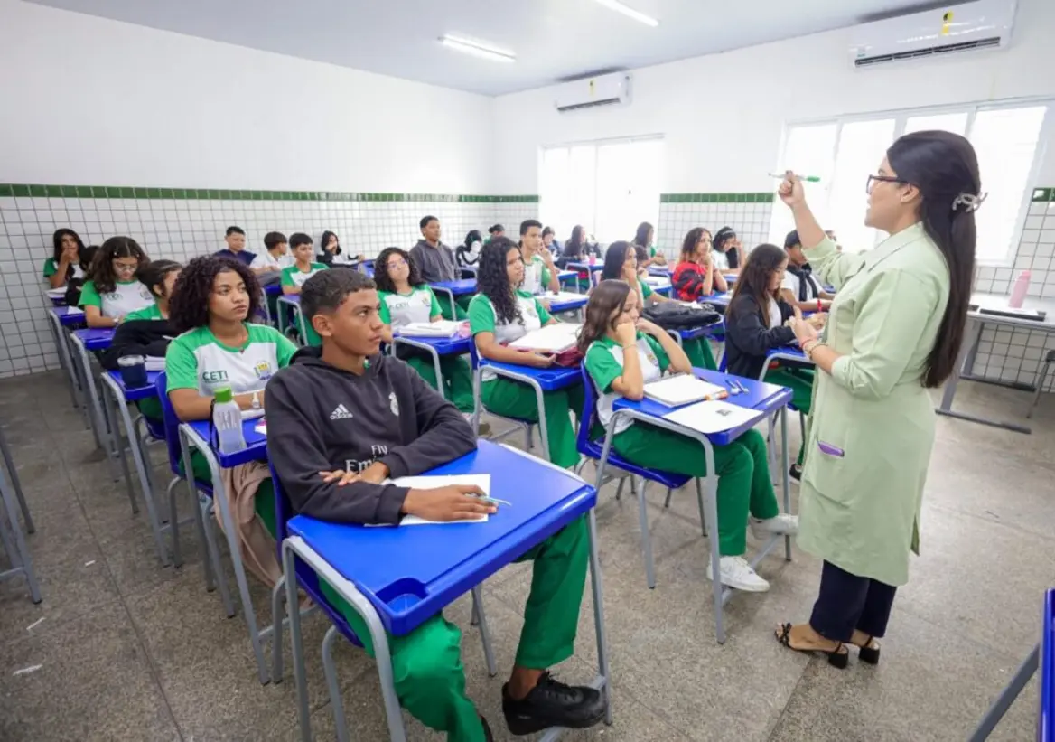 Seduc convoca 541 profissionais para reforçar ensino de tempo integral no Piauí 1 Professora ministra aula em sala da rede estadual, apontando para a lousa diante de estudantes.