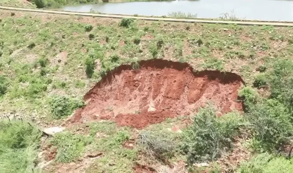 Retroescavadeira trabalhando no vertedouro da Barragem da Barra do Campestre em Coronel José Dias, Piauí, durante ações emergenciais para evitar rompimento.