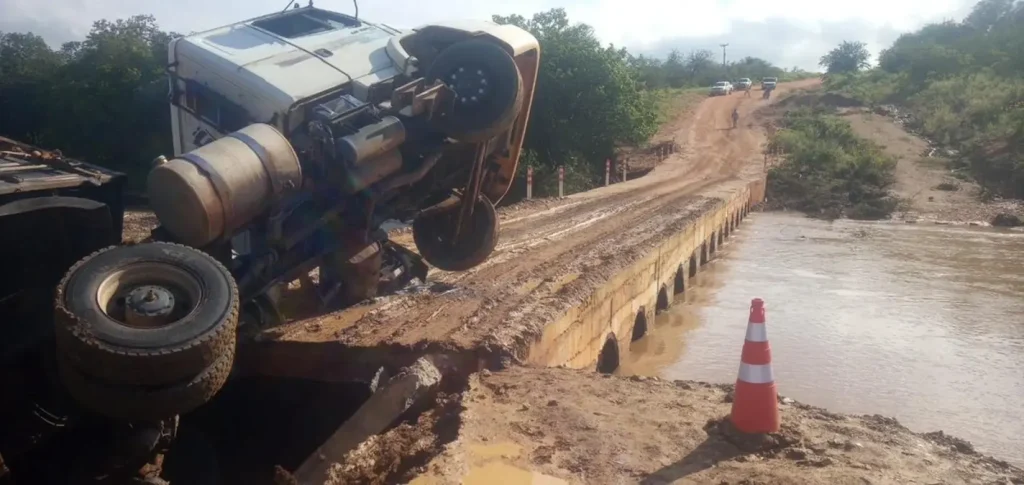 Caminhão de materiais de construção parcialmente tombado em passagem molhada alagada e danificada por chuvas na zona rural de Dom Inocêncio.